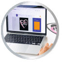 A laptop displays a heart design on the screen while a hand uses a mouse.