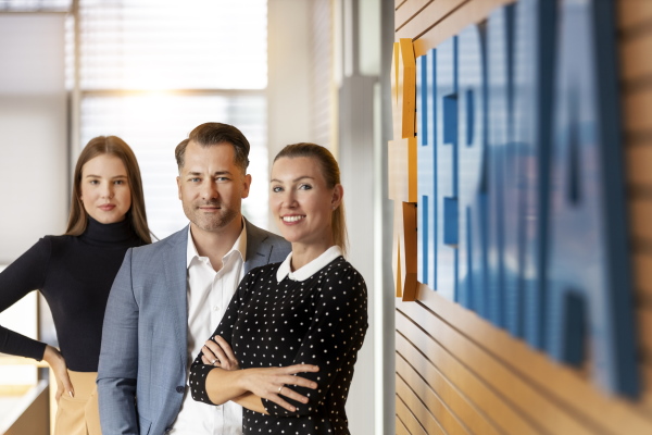 Employees in front of the logo
