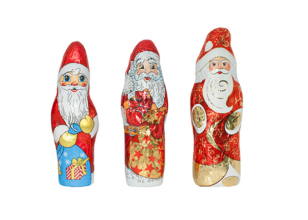 Three decorative chocolate Santas, each in different designs and colours, stand side by side.