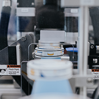 Machines in a production line for filling containers, with a focus on labelling and packaging.