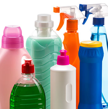 Various bottles of cleaning products in different colours and shapes, including spray bottles and pump bottles.