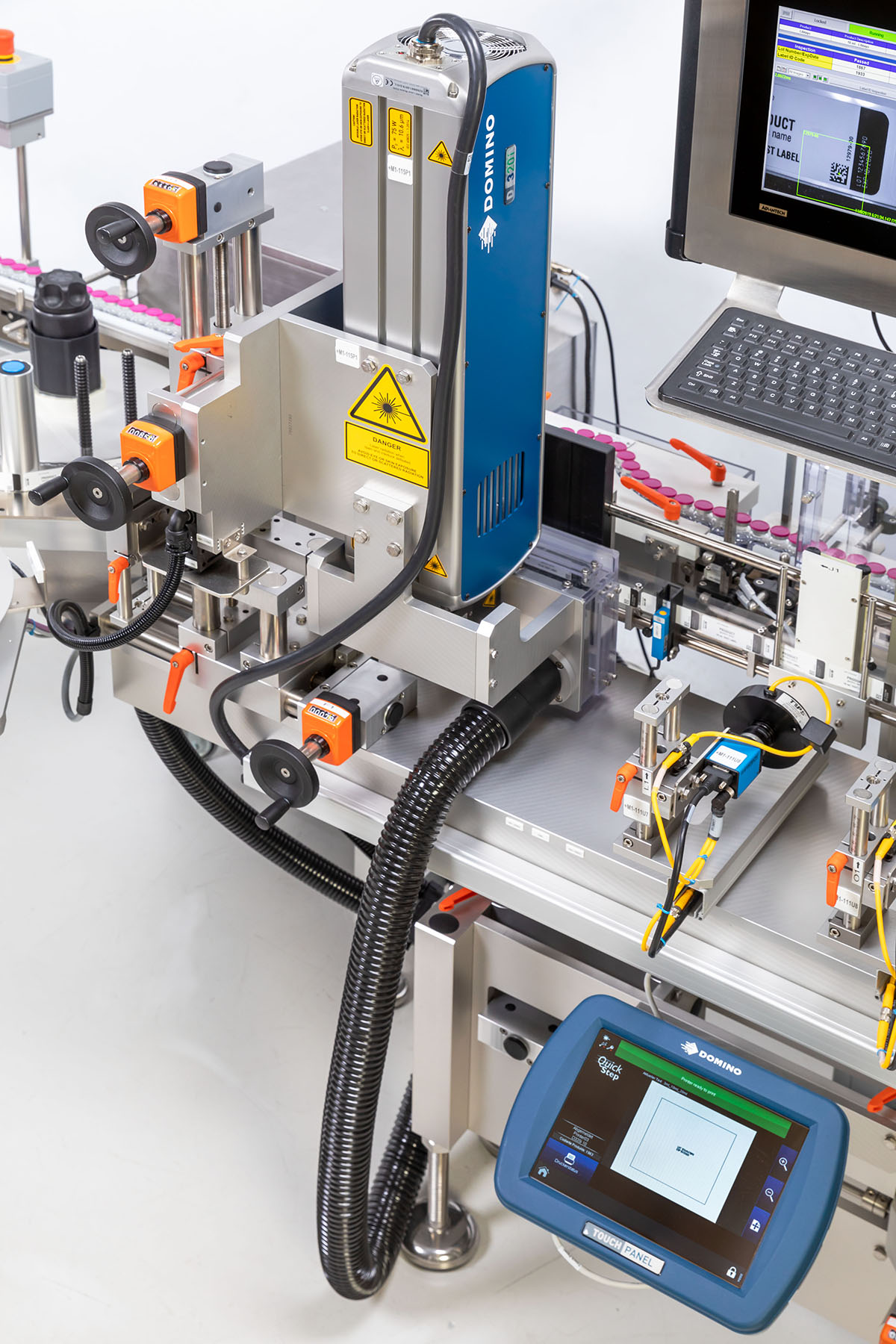 Industrial labelling machine with a print head, control screen, and various connections for labelling and coding.