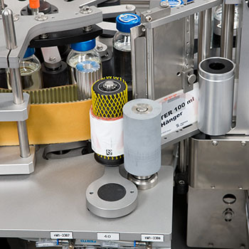 Machine for labelling bottles with various labels and containers in an industrial setting.