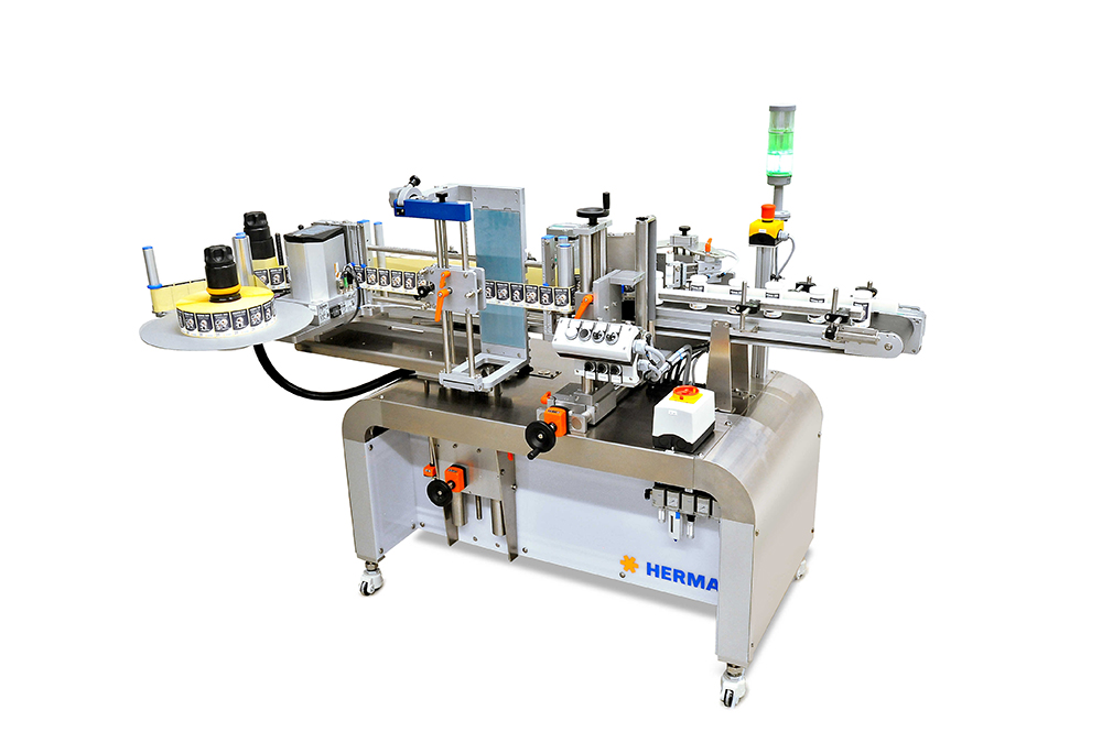 A labelling machine with various components for labelling bottles or containers, equipped with a control panel and conveyor belts.