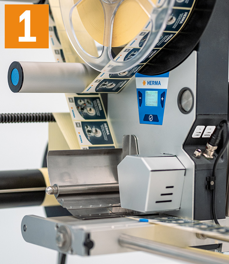 Labelling machine with a roll of labels, control display, and operating controls. The machine is ready for the labelling process.