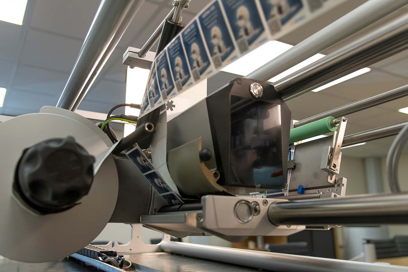A printing machine with a roll mechanism that processes multiple prints of identification cards or similar documents.
