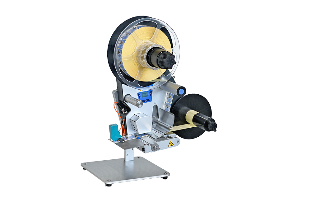 A labelling device with two rollers, a control unit, and a sturdy base, suitable for various labelling applications.