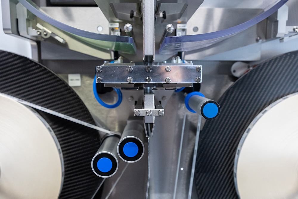 Machine with multiple tubes and blue handles, designed for processing materials or products.