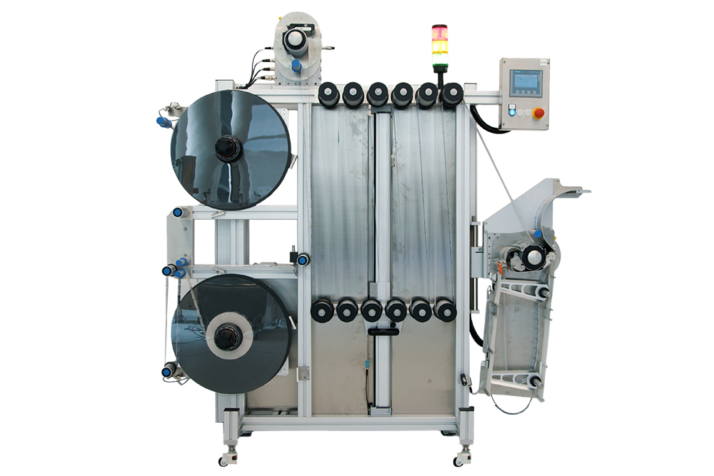Machine for processing films with two large spools, control unit, and output slot on the right side.