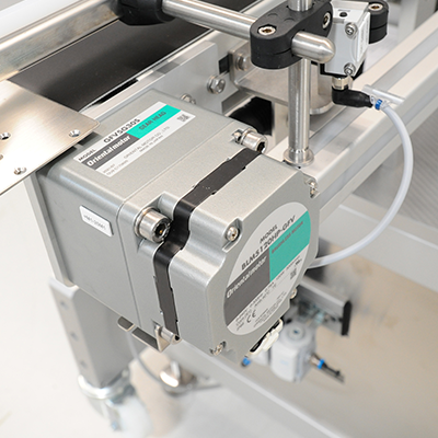 An electric engine with a conveyor belt mounted on an industrial machine for automating production processes.