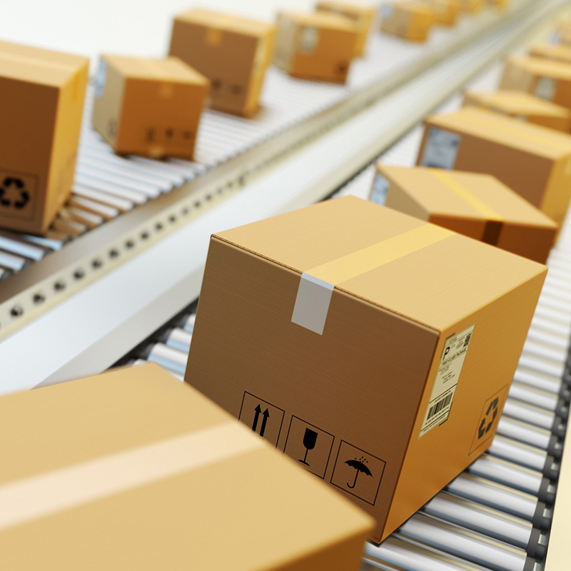 Shipping and pallet labels: Shipping label on brown boxes, on conveyor belt in logistics, from the front.