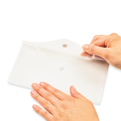Eine Hand hält ein weißes Blatt Papier, während die andere Hand es sanft auf eine flache Oberfläche drückt.
