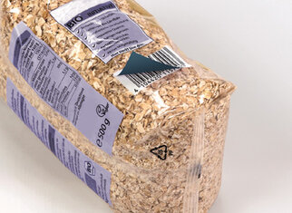 Packaging with organic oats, 500 g, displays nutritional information and an ingredient list on the side. The details are presented on an opaque label.