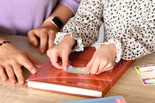 Desk with a book that is covered in protective book film.