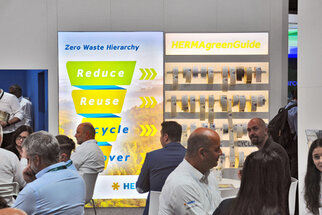 Two information walls at a trade fair, one featuring the Zero Waste Hierarchy and the other showcasing the HERMAgreenGuide.