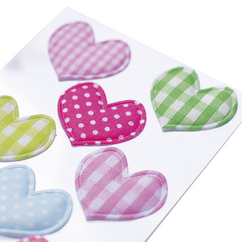 Bunte Herzaufkleber in verschiedenen Farben und Mustern, darunter gepunktete und karierte Designs.