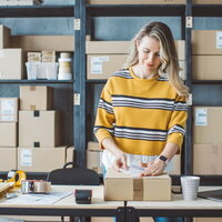 Woman sticking a label on a package.