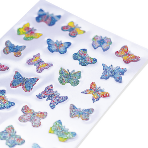 Bunte Glitzeraufkleber in Form von Schmetterlingen, angeordnet auf einem weißen Hintergrund. Verschiedene Farben und Designs sind sichtbar.