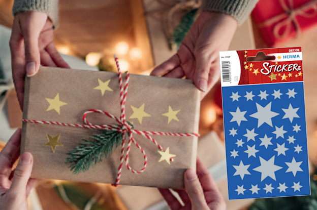 Gift wrapping with golden stars, surrounded by Christmas decorations and two rolls of wrapping paper in red and blue.