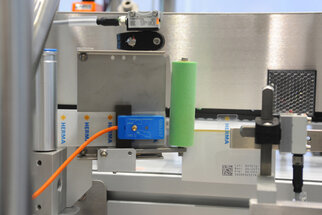 Labelling machine with sensors and a green roller mechanism that applies labels to products.