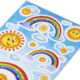 Bunte Aufkleber mit Sonnen, Regenbögen und Wolken auf einem hellblauen Hintergrund.