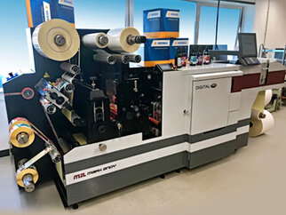 A digital printing machine with multiple rolls and a control panel, used for label production.
