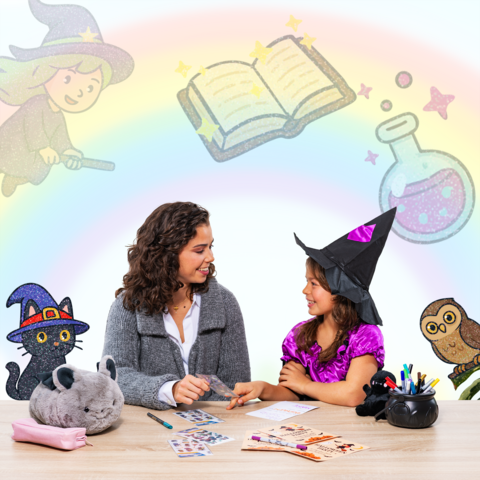 A woman and a girl in witch costumes sit at a table, surrounded by craft materials and magical illustrations.