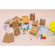 Bunte Geschenktüten und Bastelmaterialien auf einem Tisch, darunter Aufkleber, Luftballons und Scheren.