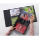 Eine Person hält ein Fotoalbum mit mehreren Bildern, darunter Porträts und Gruppenfotos, in einem schwarzen Album.