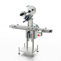 Labelling machine with conveyor belt and two rolls for labels, equipped with a control panel for operation.