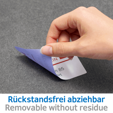 Eine Hand zieht einen ablösbaren Aufkleber von einer Oberfläche, mit dem Text „Rückstandsfrei abziehbar“ sichtbar.