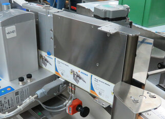 A labelling machine with multiple label rolls and control elements, designed for industrial applications.