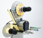 Labelling machine with two rollers, a control unit, and a display for adjusting the settings.