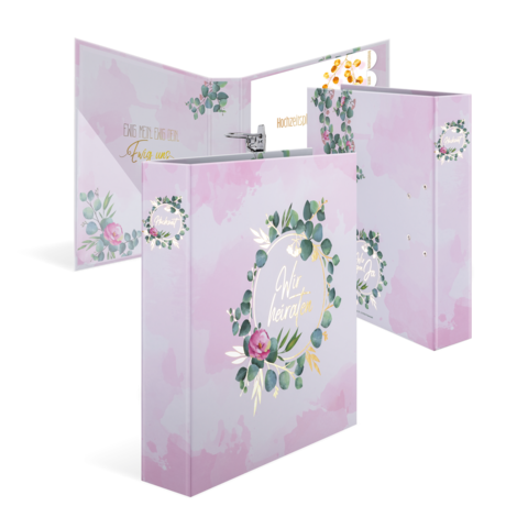 Ein rosa Ordner mit floralen Motiven und dem Text "Wir heiraten" auf der Vorderseite, geöffnet mit Innentaschen.