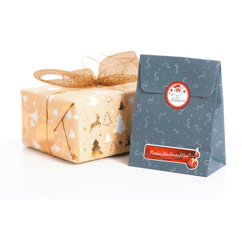Geschenkverpackung in Gold mit Weihnachtsmotiven und eine blaue Tüte mit dem Aufdruck "Frohe Weihnachten".