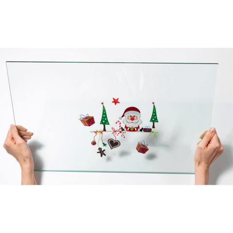 Eine transparente Glasplatte wird von zwei Händen gehalten, mit weihnachtlichen Motiven wie einem Schneemann, Geschenken und Tannenbäumen.