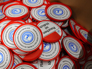 Red and white stickers with the text 'Smoking is deadly' and a symbol, stacked in a box.