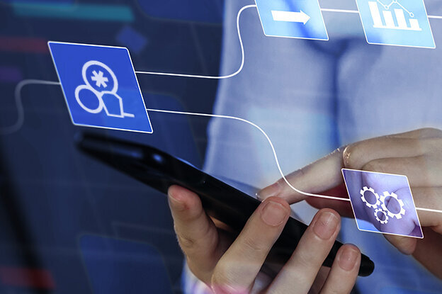 A person is holding a smartphone while digital symbols and charts are displayed in the background, representing data and networks.
