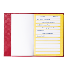 Ein geöffnetes Notizbuch mit handschriftlichem Gedicht über einen Hahn, datiert auf den 23. Mai, auf gelben linierten Seiten.