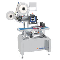 Labelling machine with rollers, control panel, and conveyor belt, manufactured by HERMA. Ideal for industrial applications.
