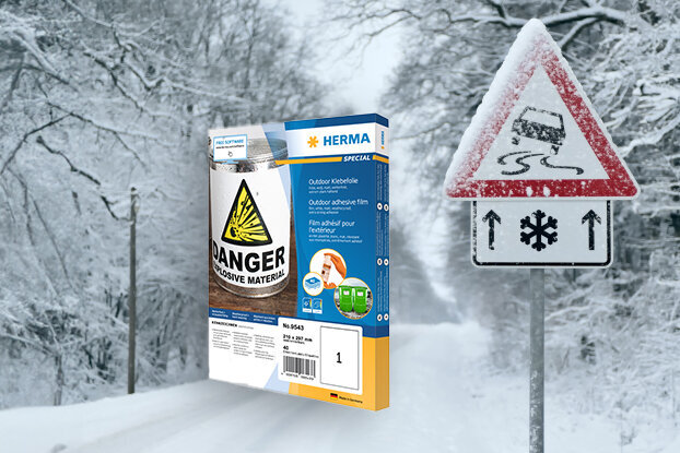 A frozen road sign warning of slippery conditions, next to a package of salt for de-icing in a snowy setting.
