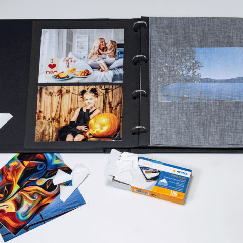 A photo album with several pictures, including portraits and landscapes, as well as some loose photo cards and a film packaging.