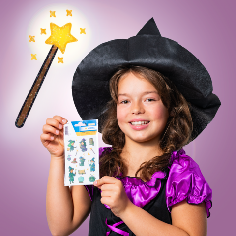 A girl in a witch costume holds a sheet of stickers and shows a wand with a sparkling star.